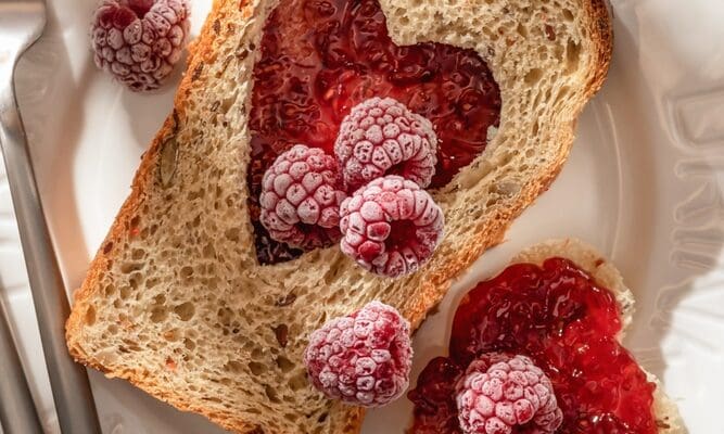 Toasted,Bread,With,Heart-shaped,Cut,And,Raspberry,Jam,On,Tile